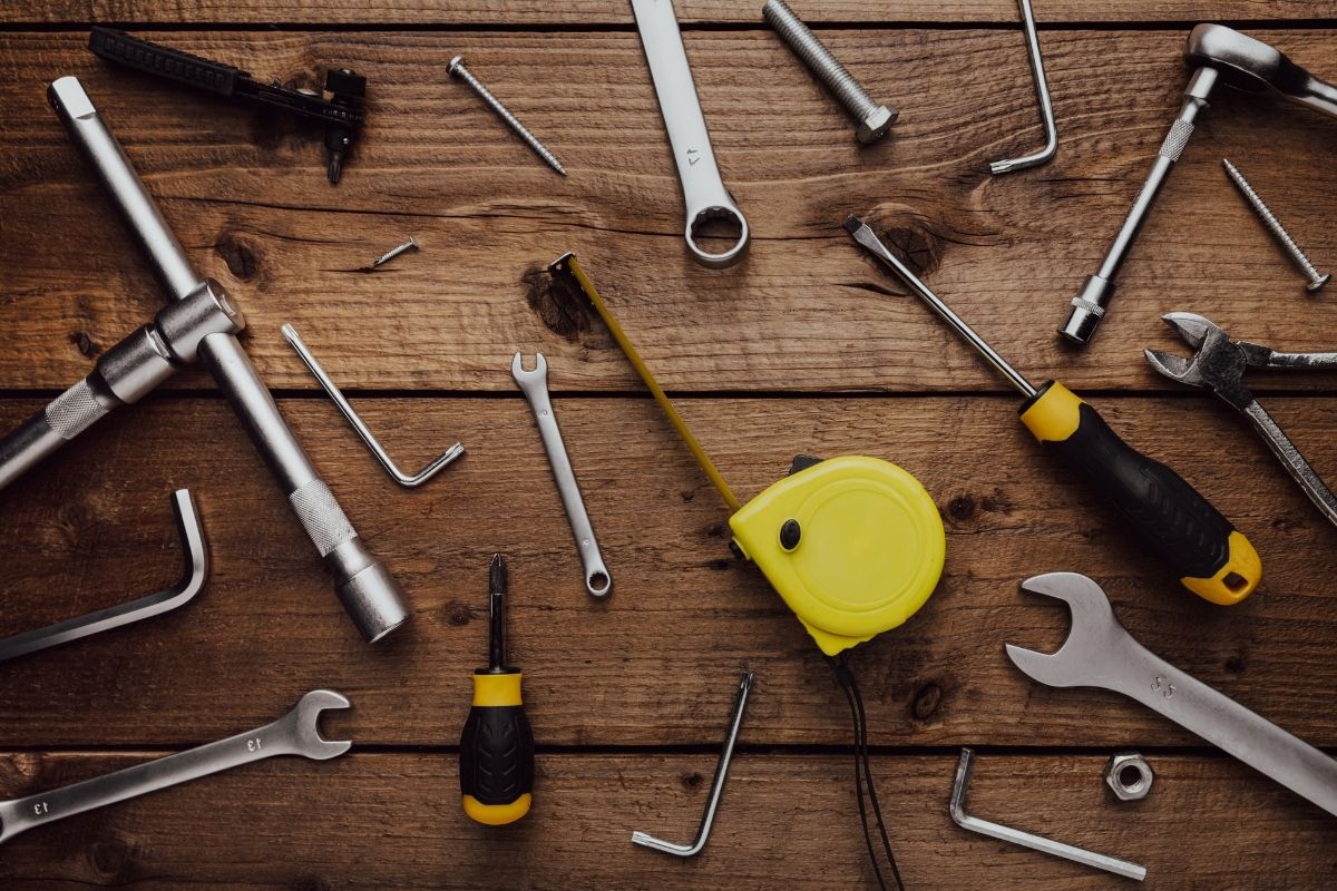 A variety of tools arranged on a wooden table, with ample empty space for text or additional content.